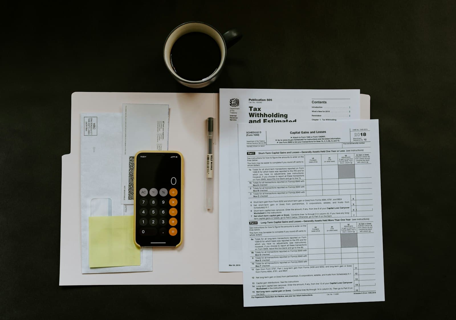 Month-end paperwork, a calculator and a ledger on a desk